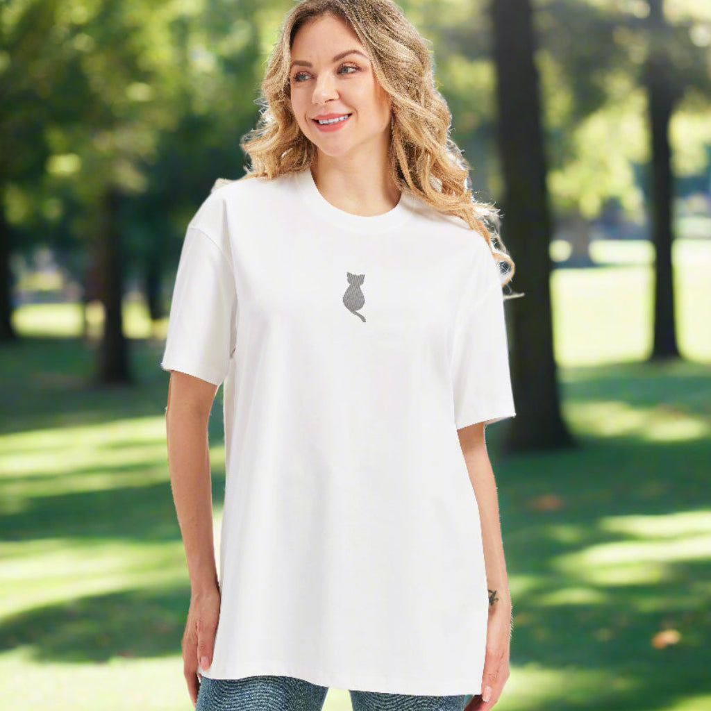 Woman in a loose fit white graphic tee with a small cat print