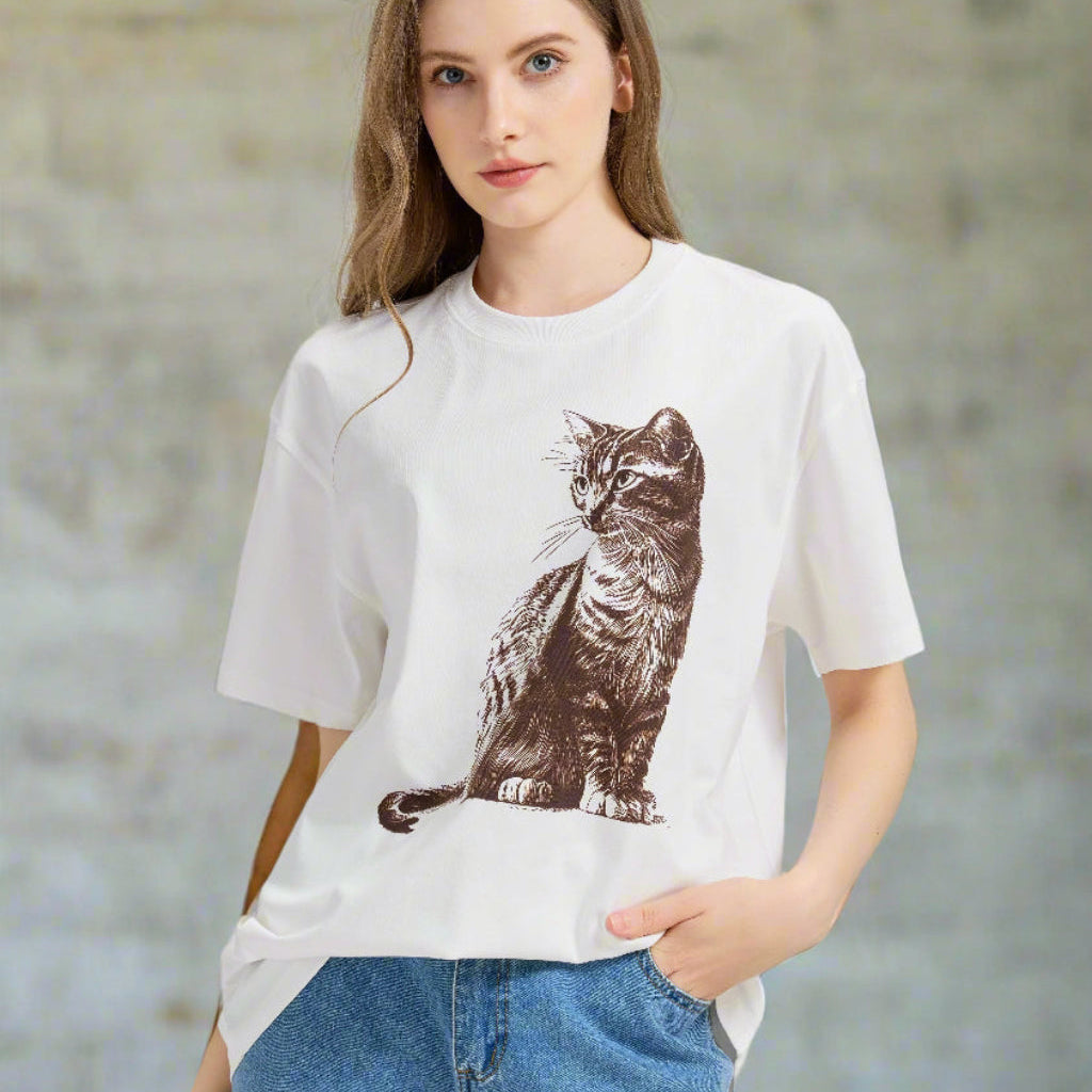 Woman wearing a white t-shirt with a cat graphic and blue jeans