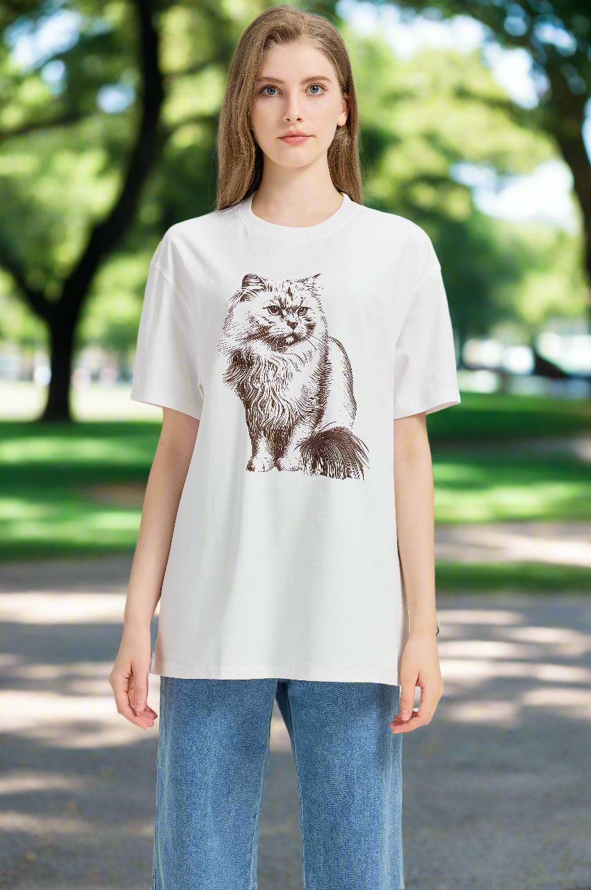 Woman wearing a white t-shirt with a cat graphic on an outdoor background