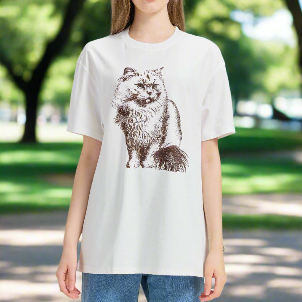 Woman wearing a white t-shirt with a cat graphic on an outdoor background