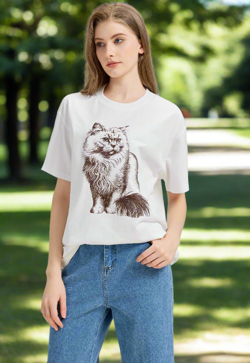 Woman wearing a white t-shirt with a cat graphic in a park