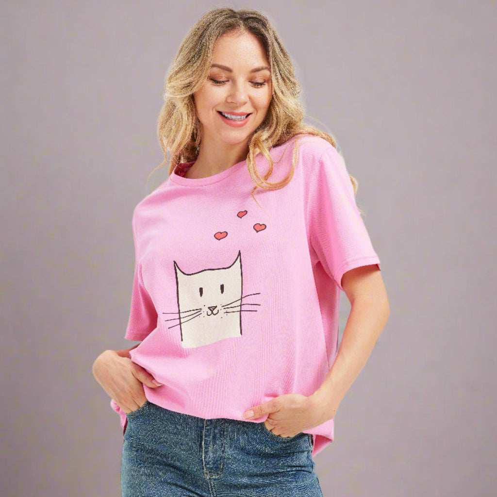 Woman wearing a pink t-shirt with a cat graphic and blue jeans